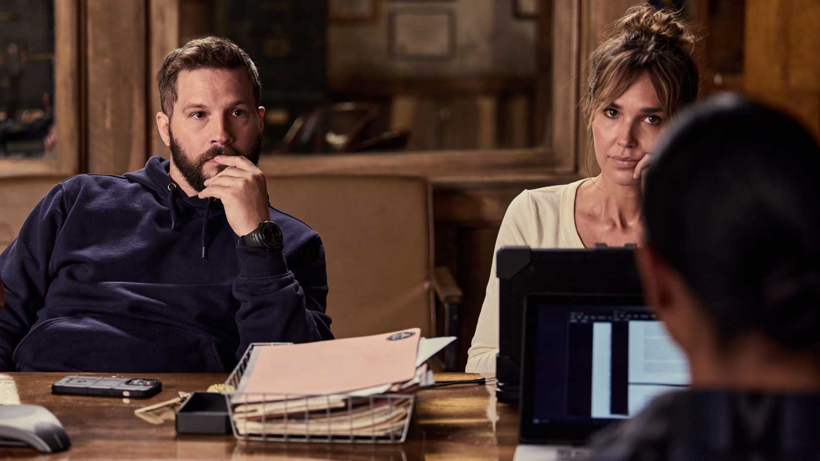 Logan Marshall-Green's Cal and Arielle Kebbell's Belle looking in thought while sitting at a desk in Marshals season 2