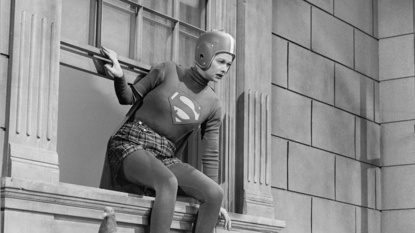 Lucy sits on a window sill while dressed as Superman in I Love Lucy episode Lucy Meets Superman
