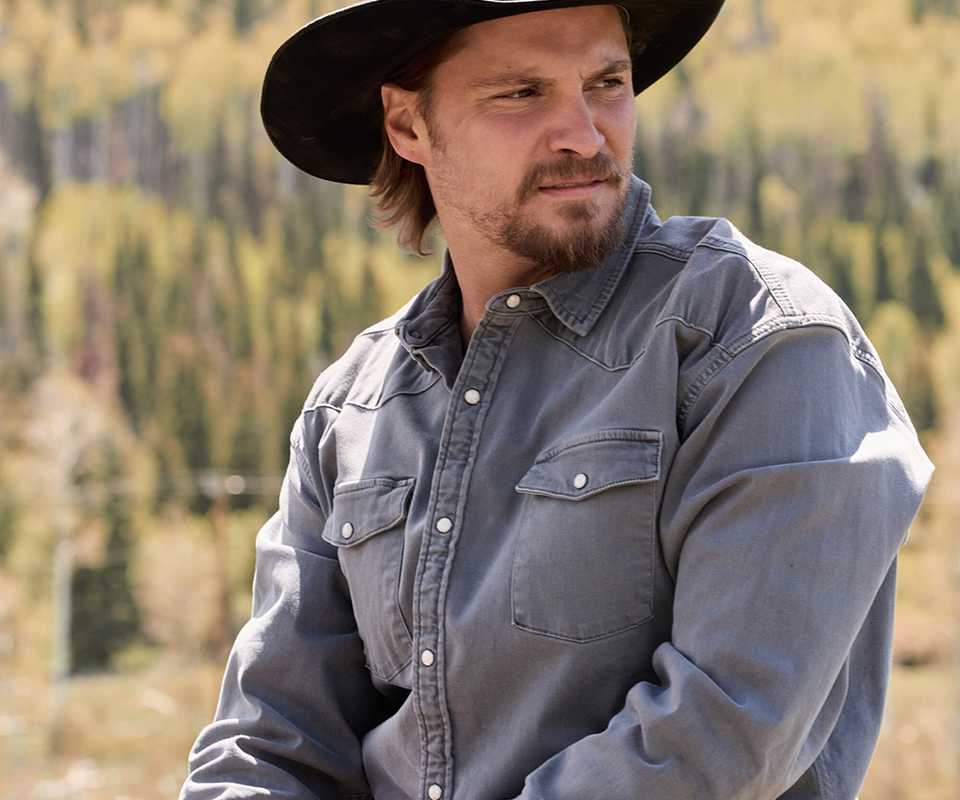 Luke Grimes' Kayce sitting atop his horse and looking to the left in Marshals season 2 vertical