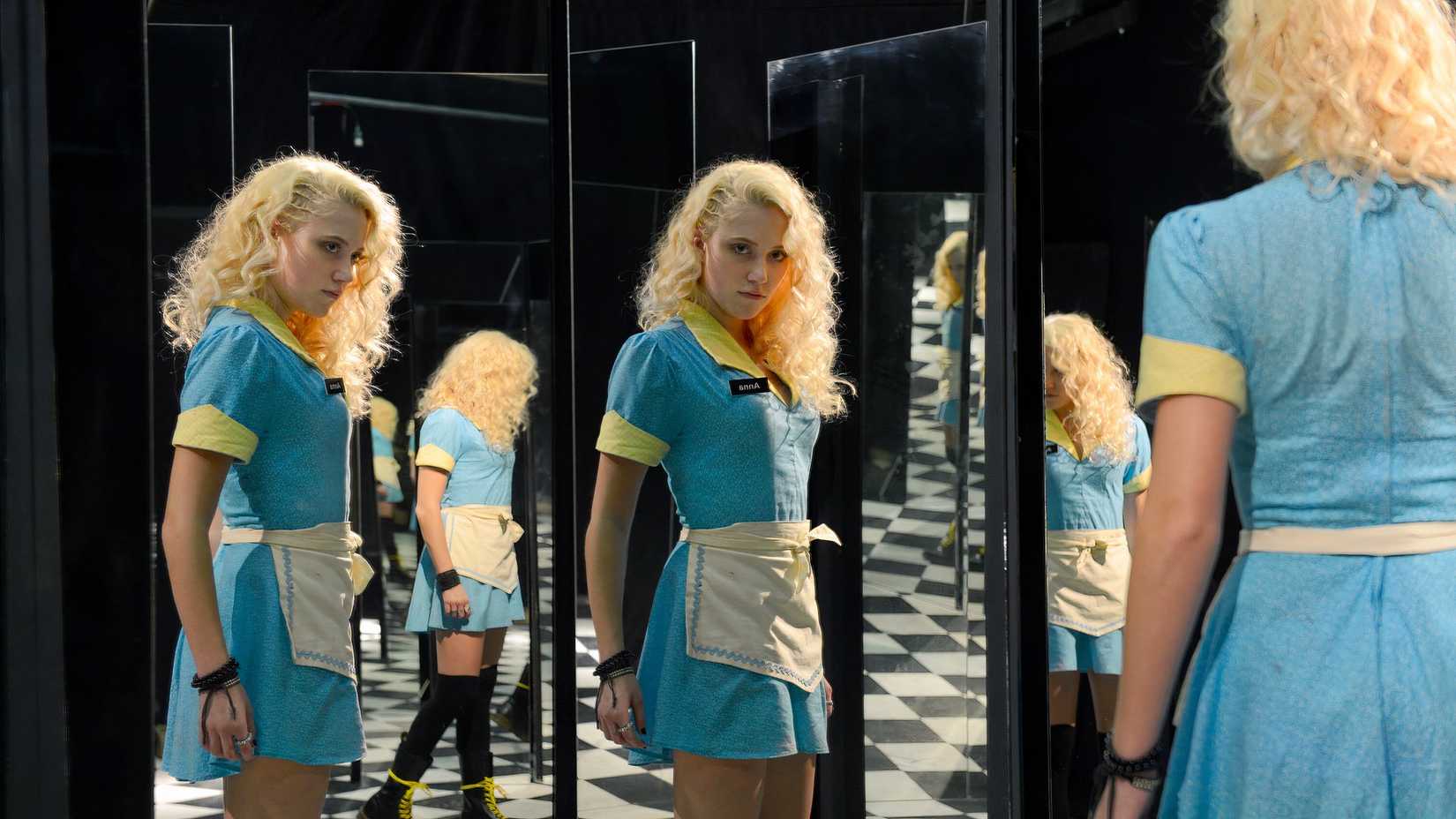 Maika Monroe as Anna looking in a hall of mirrors in The Guest (2014)