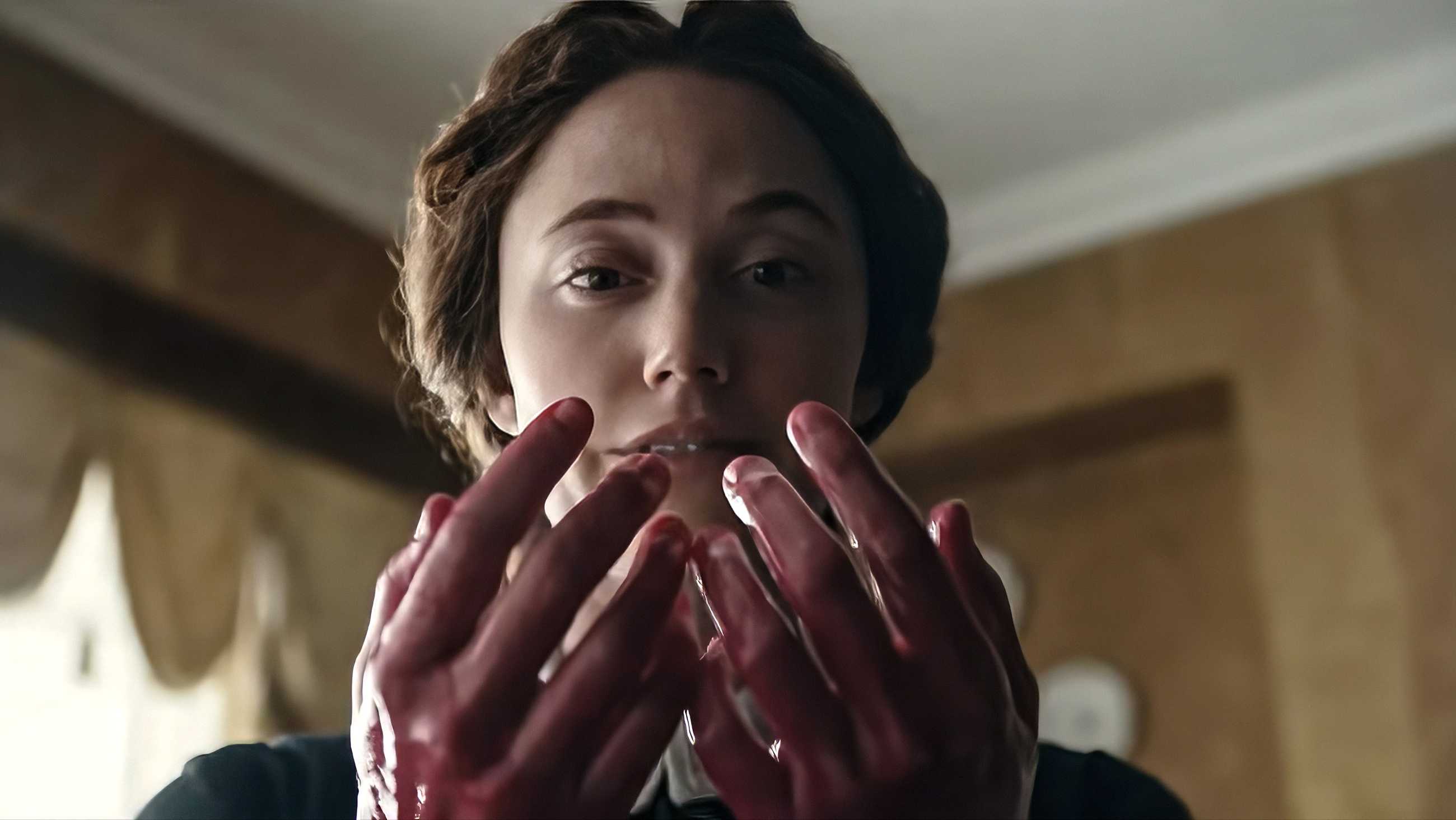 Maika Monroe staring at her bloody hands in Victorian Psycho