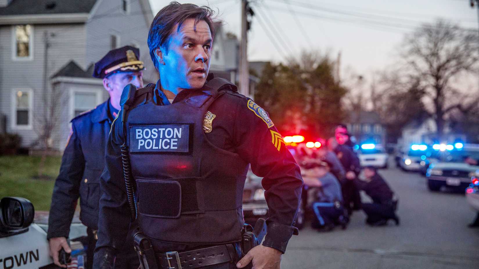 Mark Wahlberg in Boston PD uniform standing in a street full of cops in Patriots Day