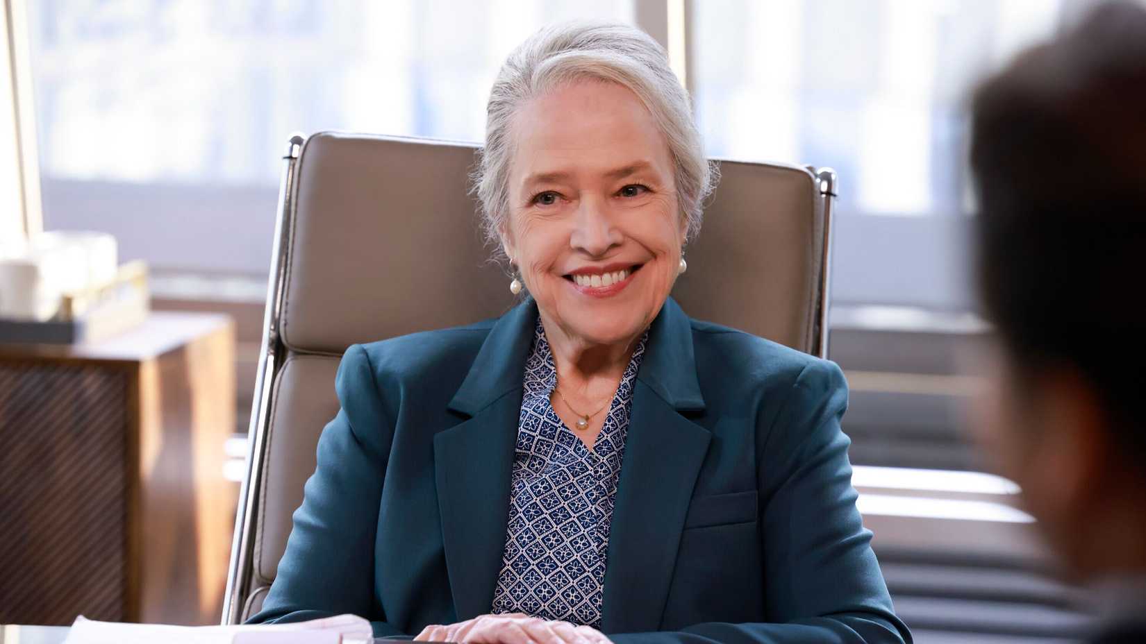 Matty (Kathy Bates) smiling at her desk in Matlock.