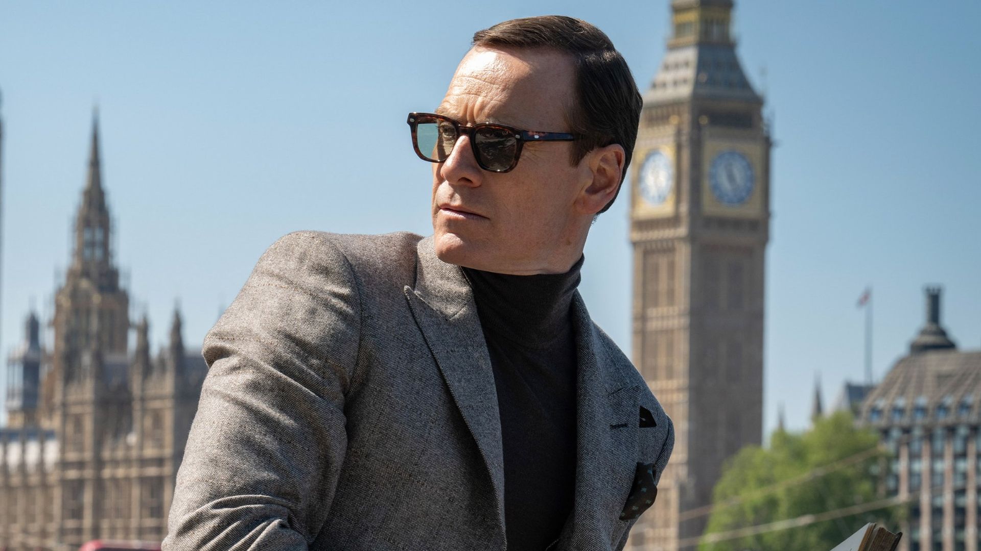Michael Fassbender with broken glasses in front of the Big Ben in London in Black Bag