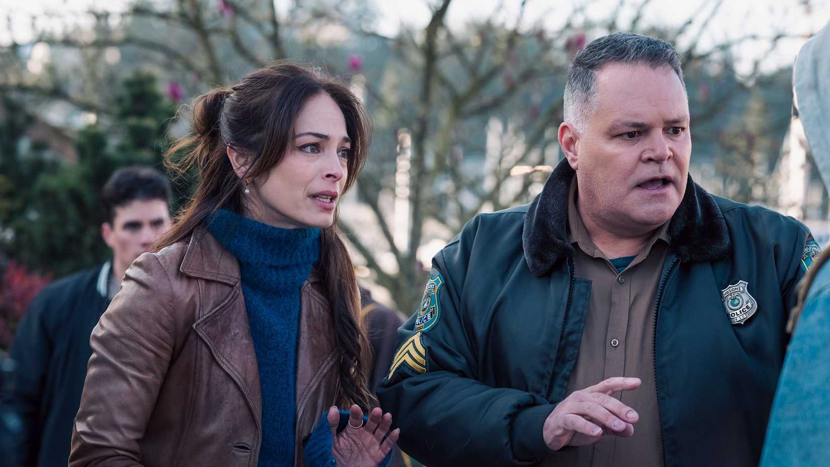 Kristin Kreuk as Cassandra Lee and Aaron Douglas as Sergeant Sid Sokolowski looking shocked in Murder in a Small Town.