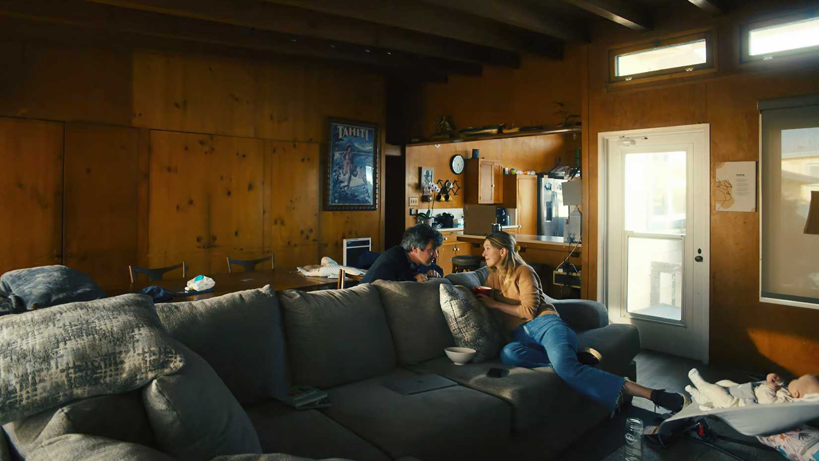 Nathan Fielder and Elizabeth Holmes staring at each other over a couch in You Can See Everything