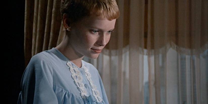 Rosemary smiling and looking down at her baby in Rosemary's Baby