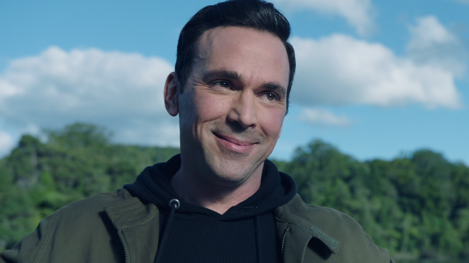 Tommy Oliver in a green jacket and black hoodie