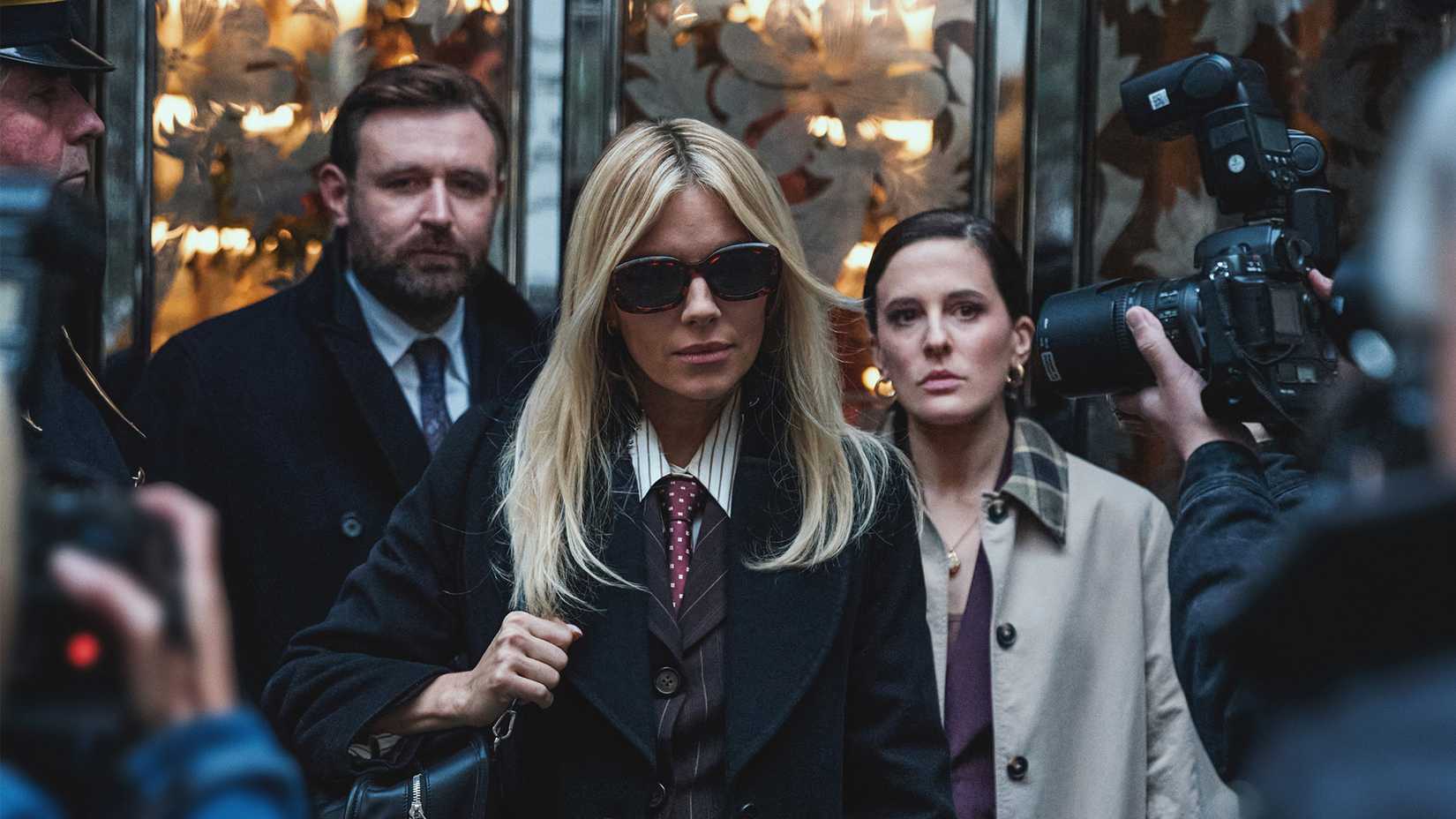 Sienna Miller wearing sunglasses and being chased by the paparazzi in War