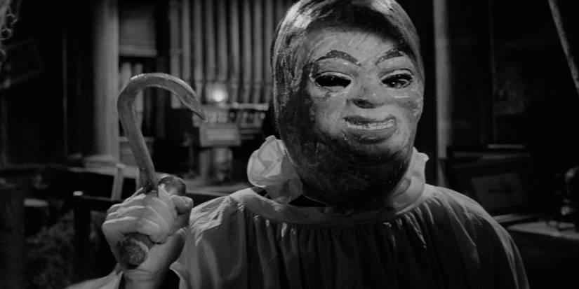 Someone in a creepy mask holding a fishhook in Paranoiac (1963)