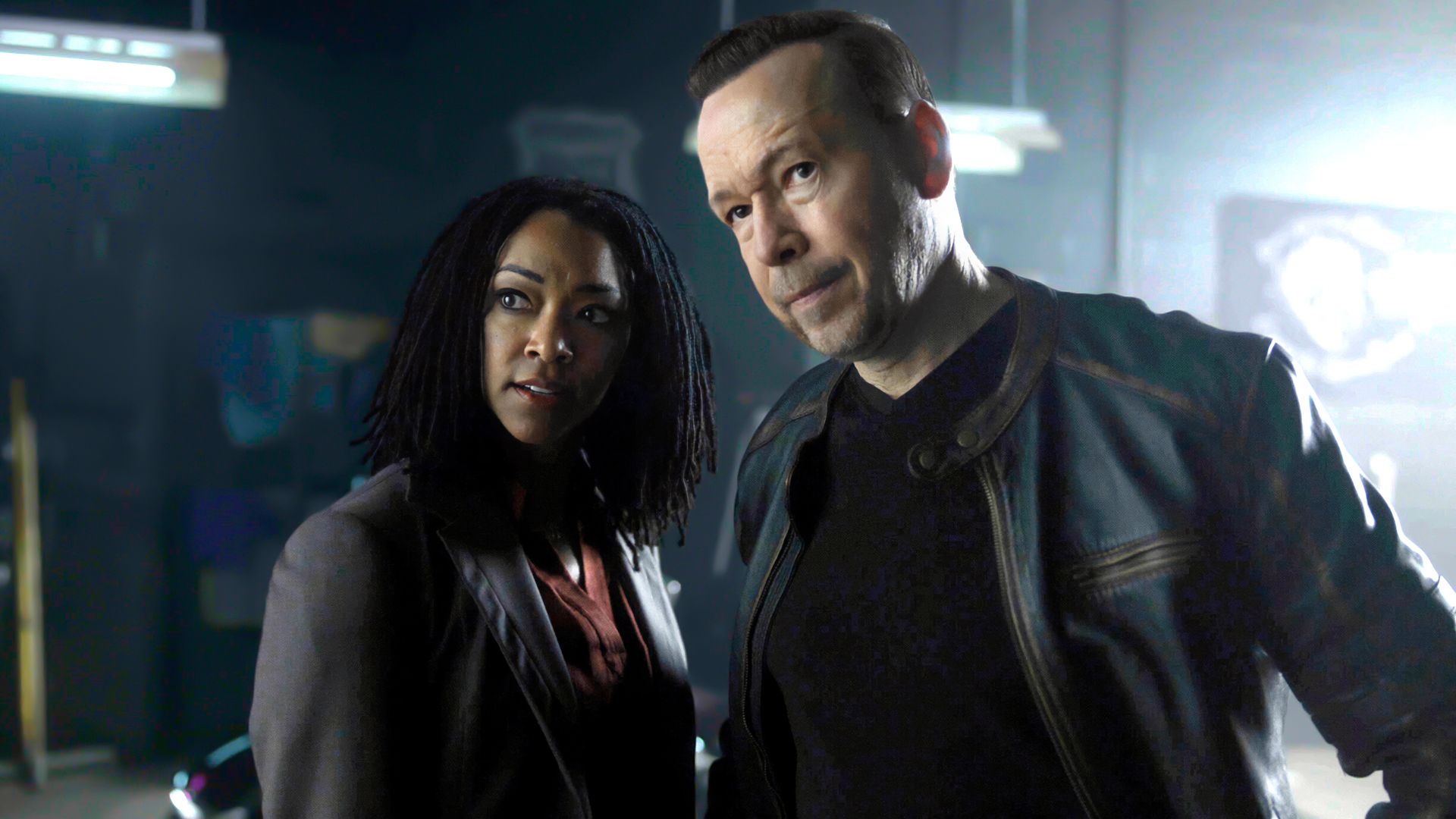 Sonequa Martin-Green's Lena and Donnie Wahlberg's Danny looking intently at something in Boston Blue season 2