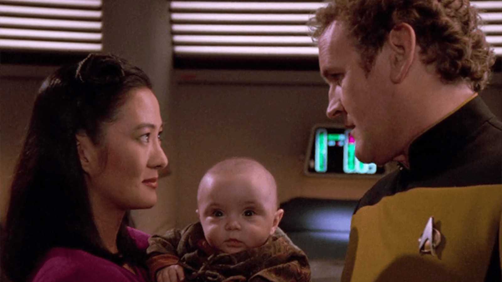 Keiko O'Brien, holding baby Molly, and Miles O'Brien talk on Star Trek: The Next Generation.