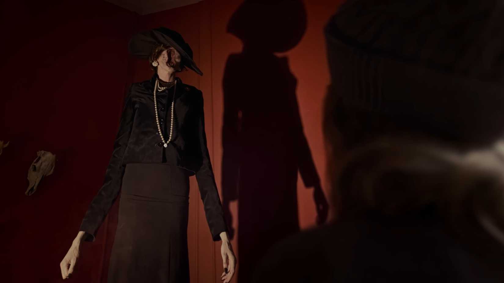 A long lady monster with a twisted face stands tall in Tenebris Somnia.