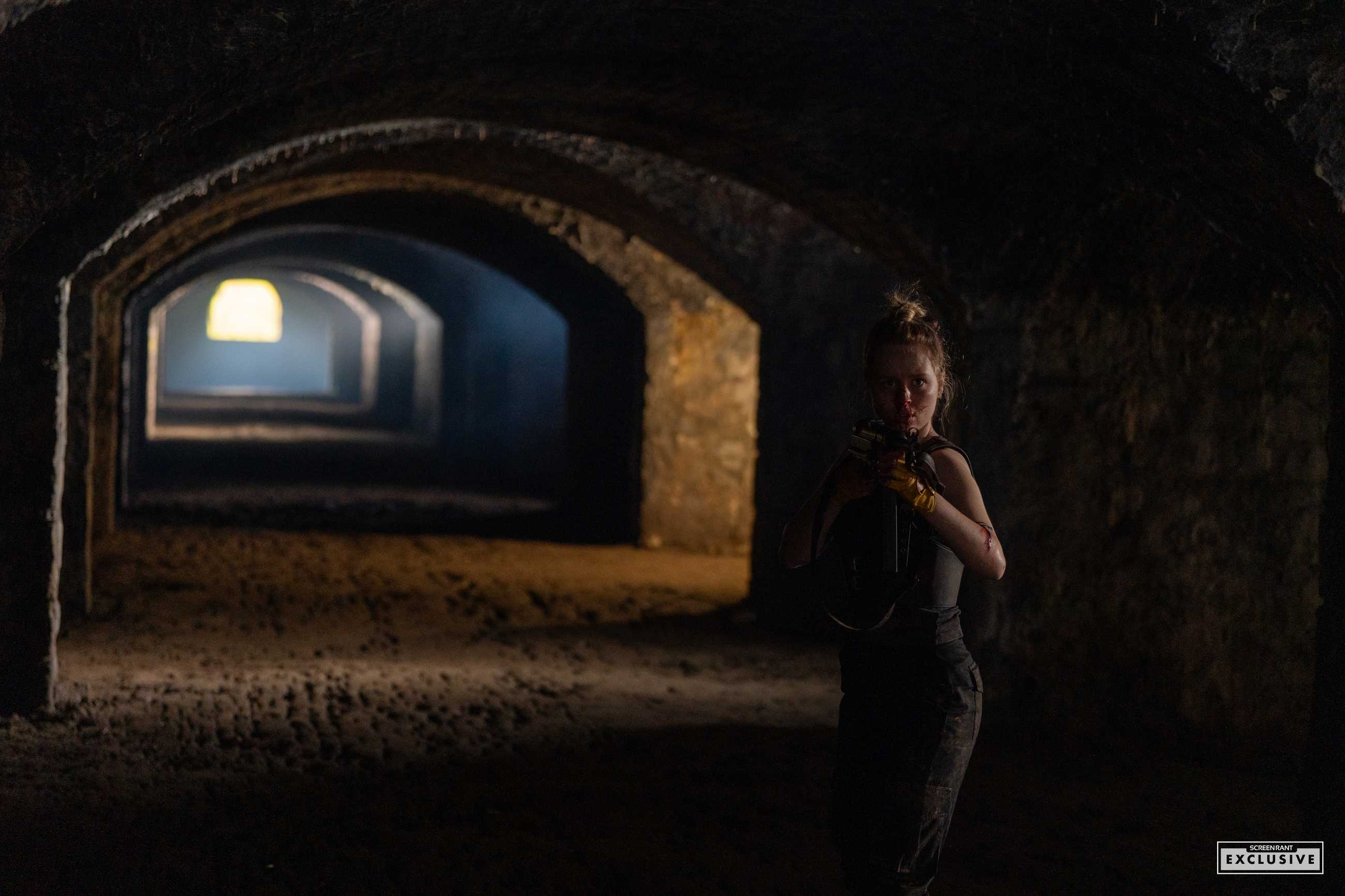 A bloodied Becky holding a crossbow hiding in the shadows in The Last Temptation of Becky