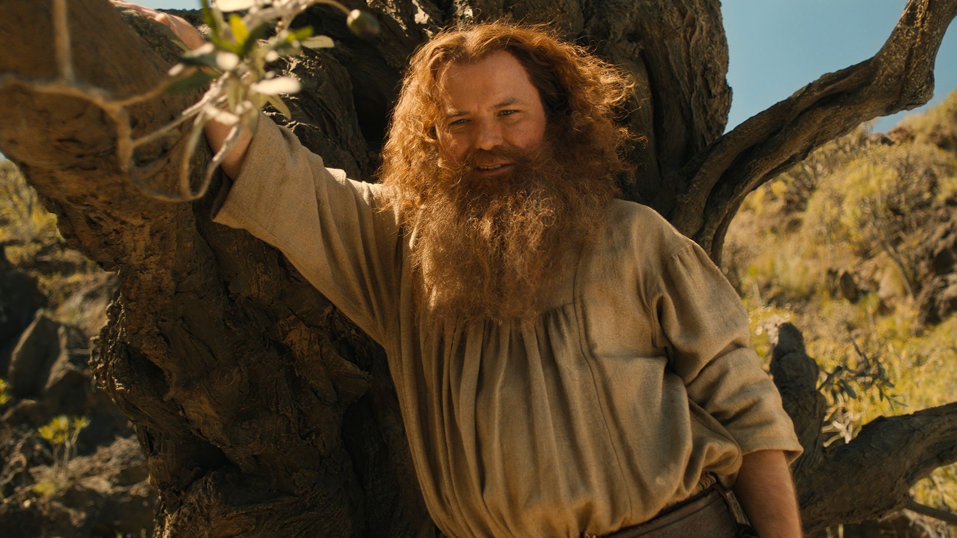 Tom Bombadil leaning against a tree in Rings of Power