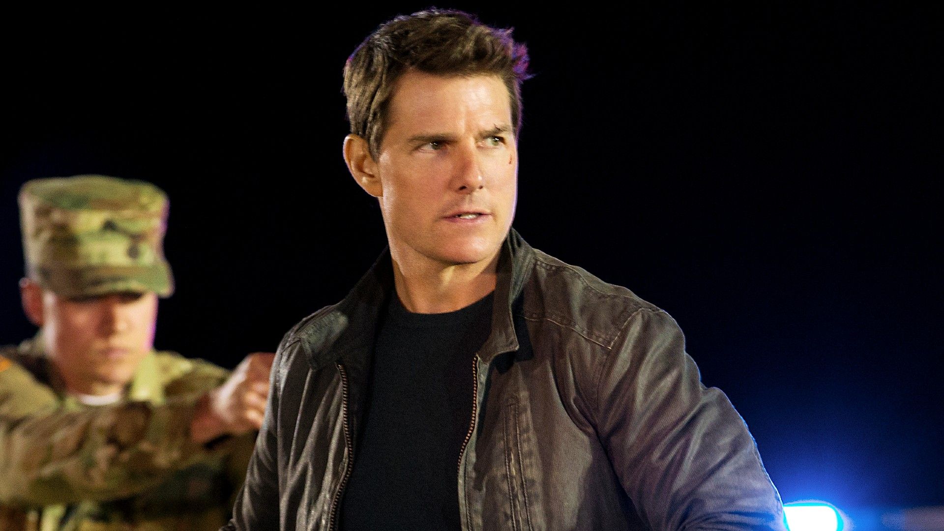 Tom Cruise looking to the side as military men surround him in Jack Reacher 2