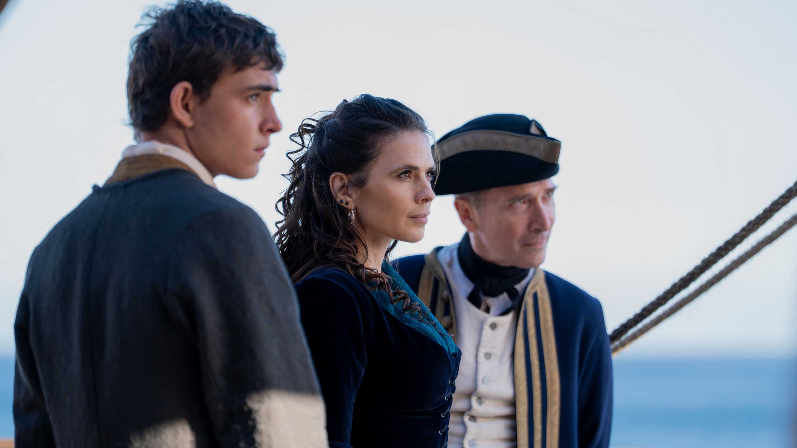 Tom Sweet's Jim and Hayley Atwell's Bess standing next to a captain and looking intently at someone in Treasure Island
