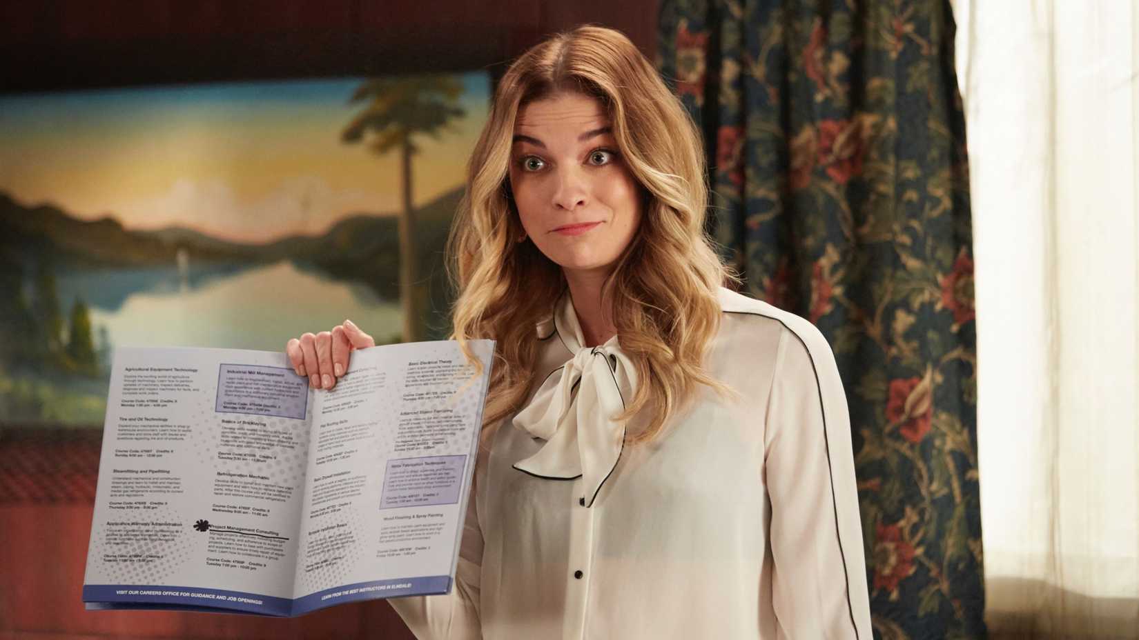 Annie Murphy holding a book in Schitt's Creek