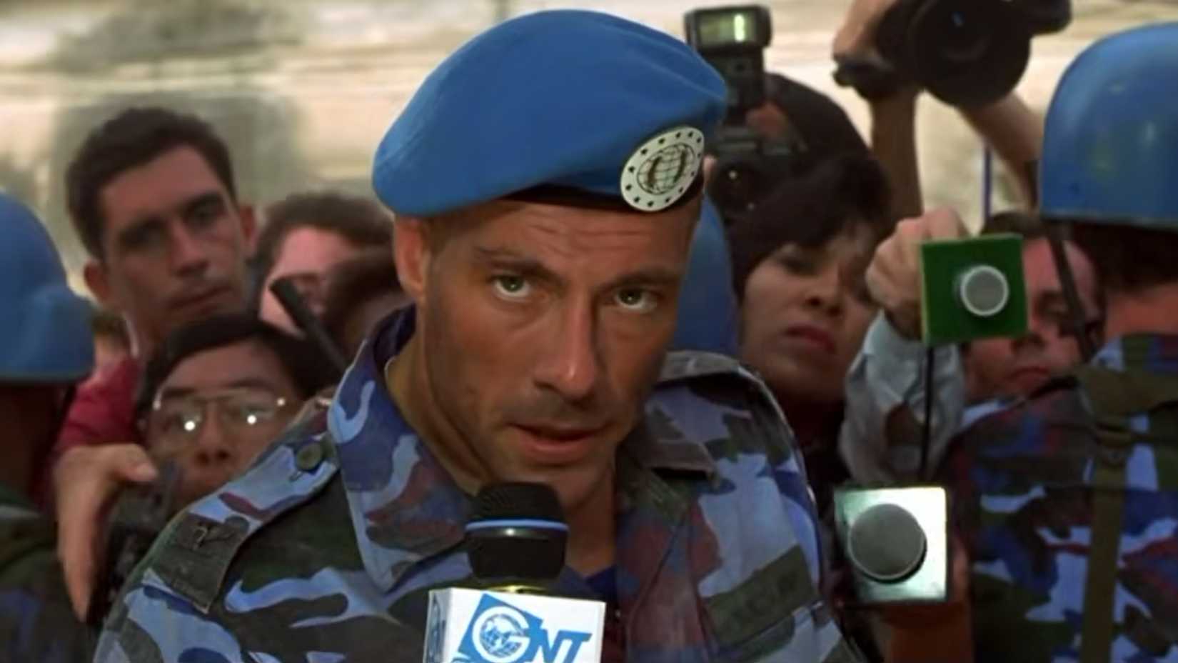 Van Damme as Guile about to speak into a microphone in Street Fighter 1994