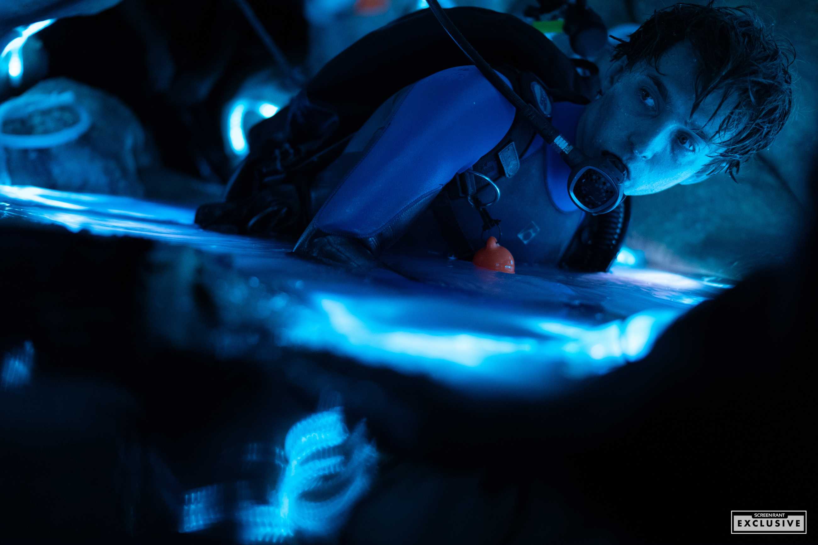 Austin Abrams in scuba gear partially submerged in water in the whale stomach set in Whalefall