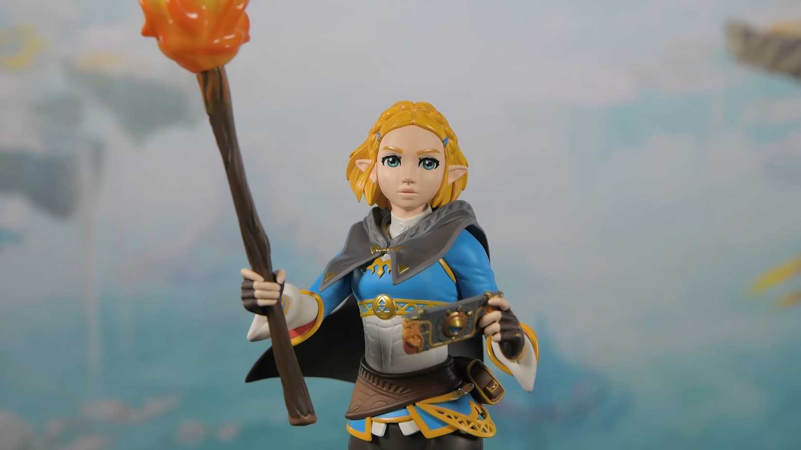 A statue of Princess Zelda from Tears of the Kingdom shows her carrying a torch.