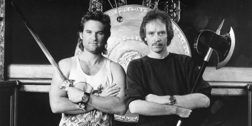 Kurt Russell and John Carpenter on the set of Big Trouble in Little China (1986) holding weapons