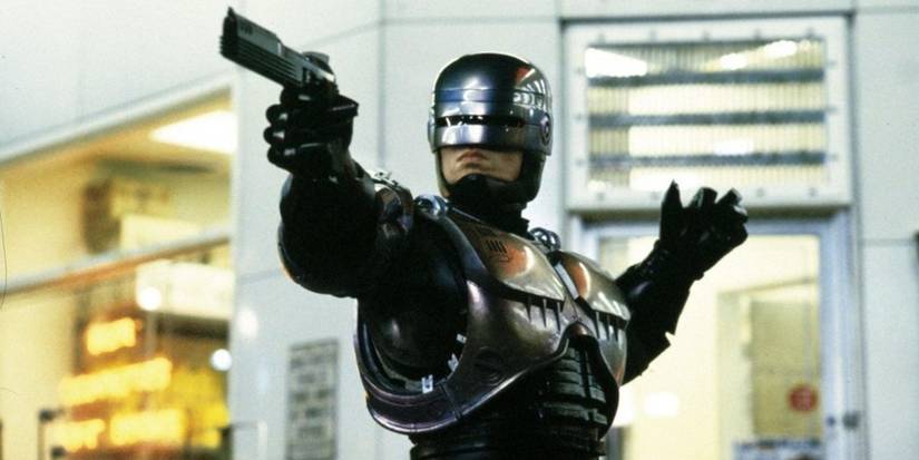 The RoboCop points a gun off screen in RoboCop 1987.