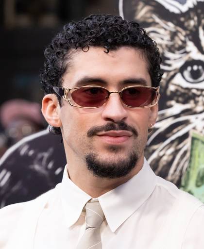Bad Bunny trägt eine rote Sonnenbrille bei einer Filmpremiere auf dem roten Teppich